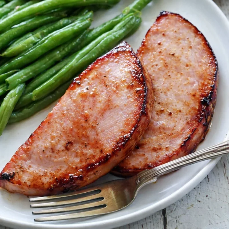 Delicious honey glazed ham steak served with sides for a quick dinner.