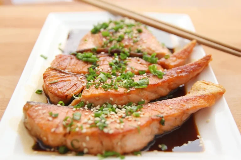 Sticky glazed salmon pieces with sesame seeds and green onions, similar to candied salmon