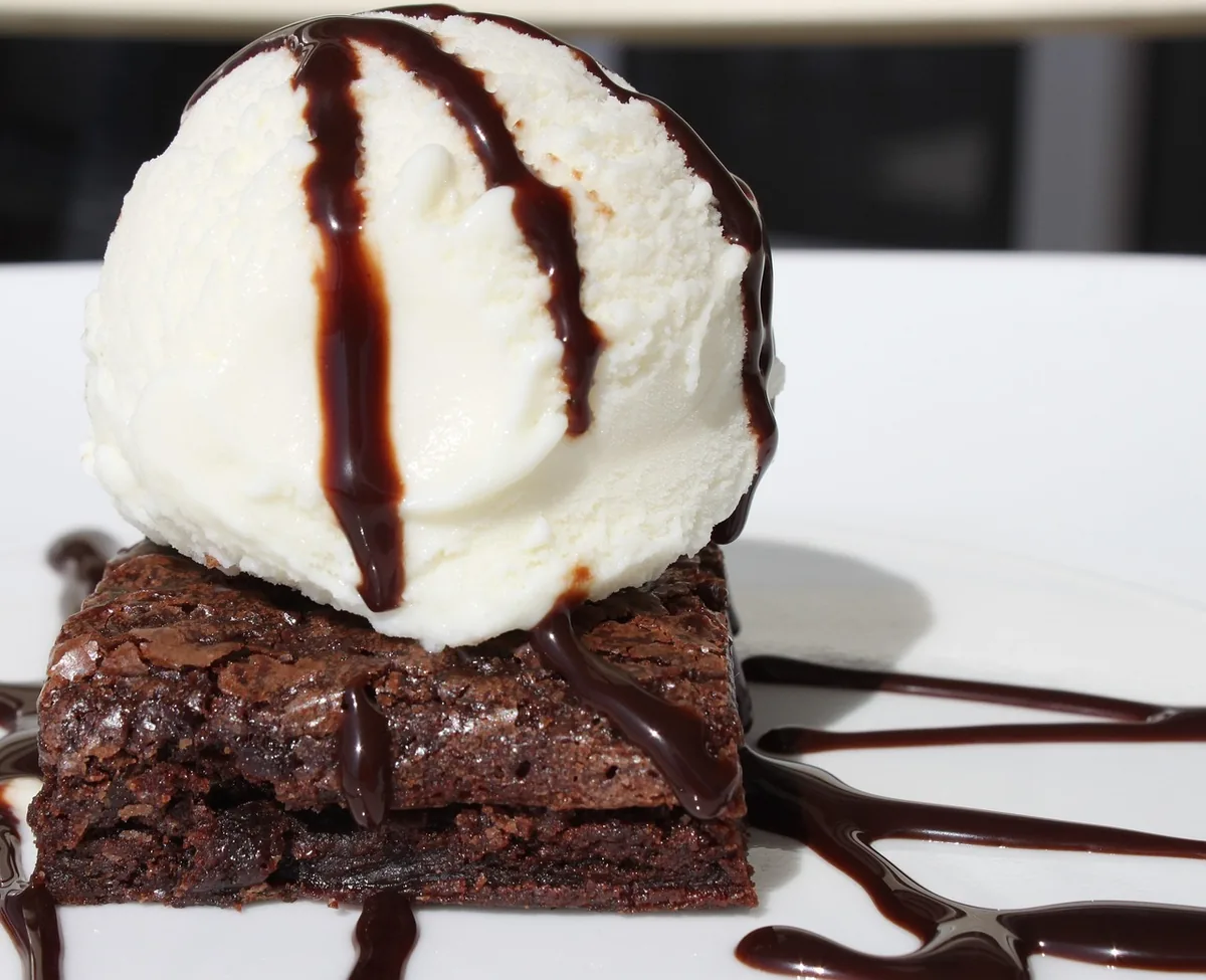 Chocolate dessert with a scoop of vanilla ice cream and chocolate sauce drizzle