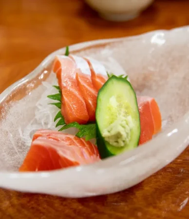 Slices of raw salmon sashimi with cucumber and wasabi, the kind of dish people buy sushi grade salmon for
