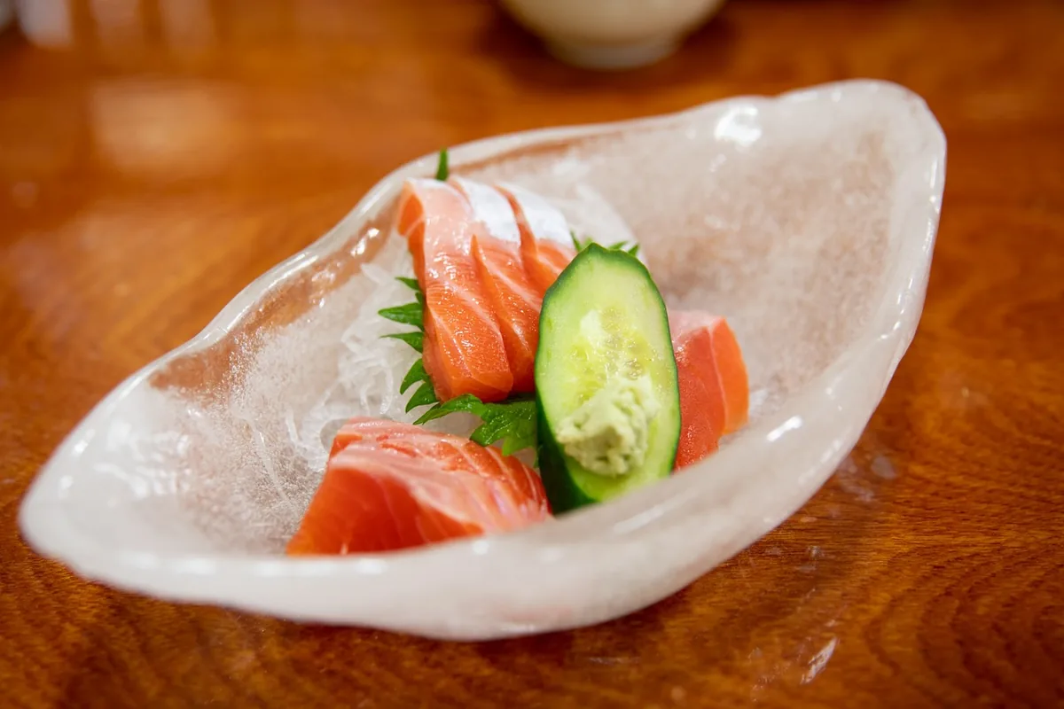 Slices of raw salmon sashimi with cucumber and wasabi, the kind of dish people buy sushi grade salmon for