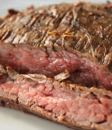 Grilled steak sliced thinly against the grain, the way to serve bavette steak, with a pink center and browned crust