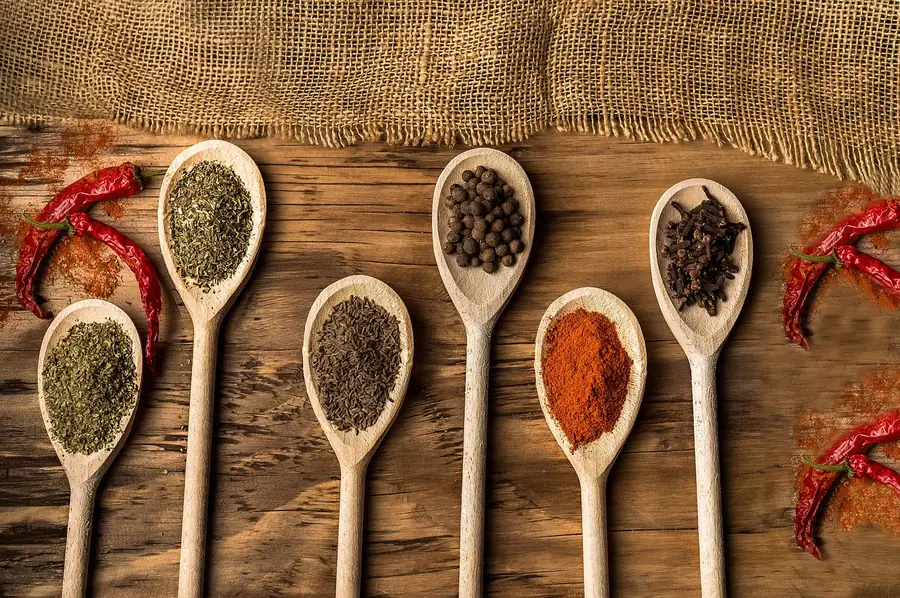 Wooden spoons of dried herbs, black pepper and paprika, the kind of spices in homemade pot roast seasoning