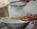 Powdered sugar being sifted over a fresh funnel cake, the finish for this funnel cake recipe