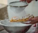 Powdered sugar being sifted over a fresh funnel cake, the finish for this funnel cake recipe