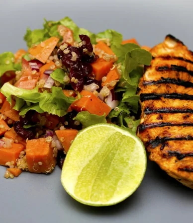Golden chicken breast served with a sweet potato salad and a lime half, a simple way to serve sous vide chicken breast