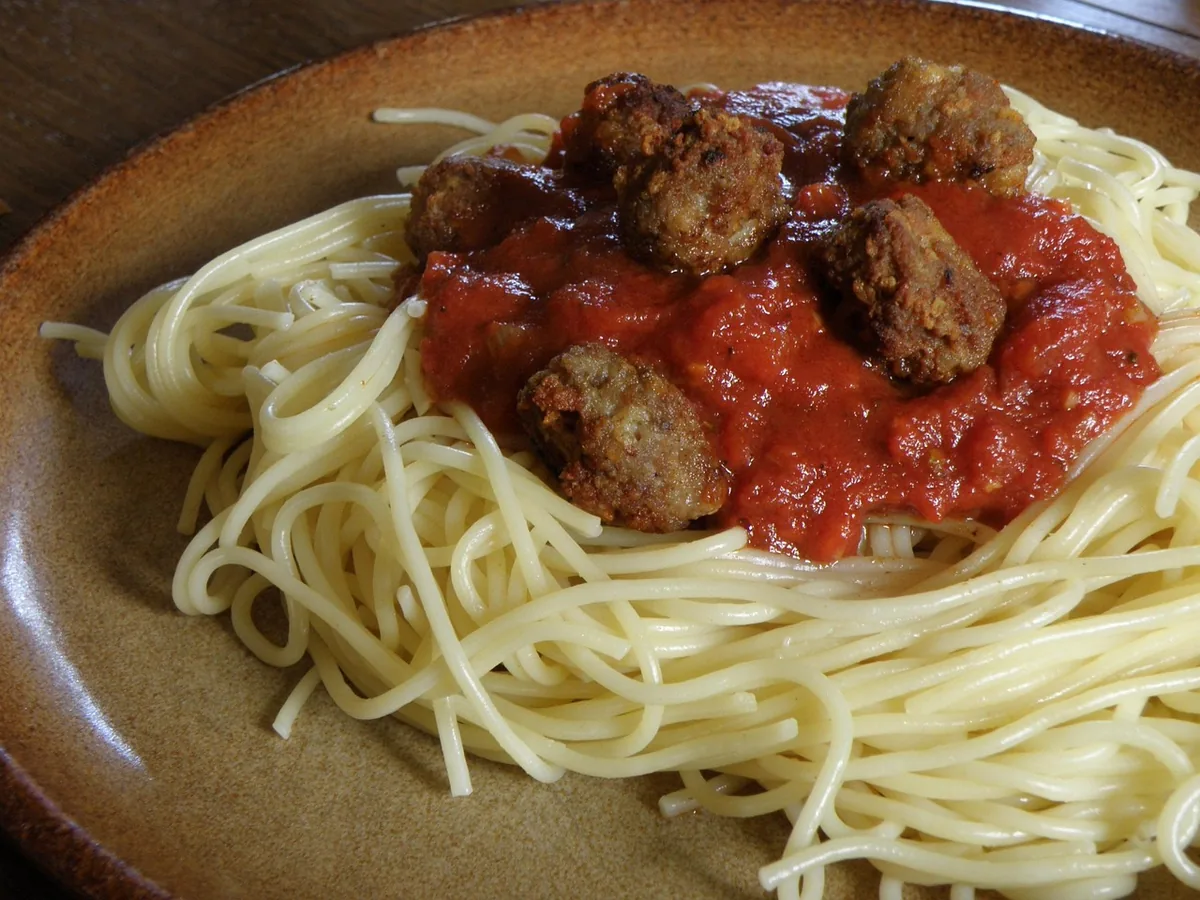 Spaghetti topped with meatballs and tomato sauce on a plate