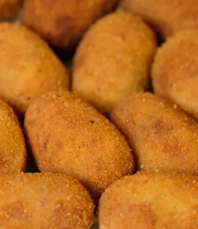 Golden fried croquettes piled on a plate, the crispy finish to aim for with this salmon croquettes recipe