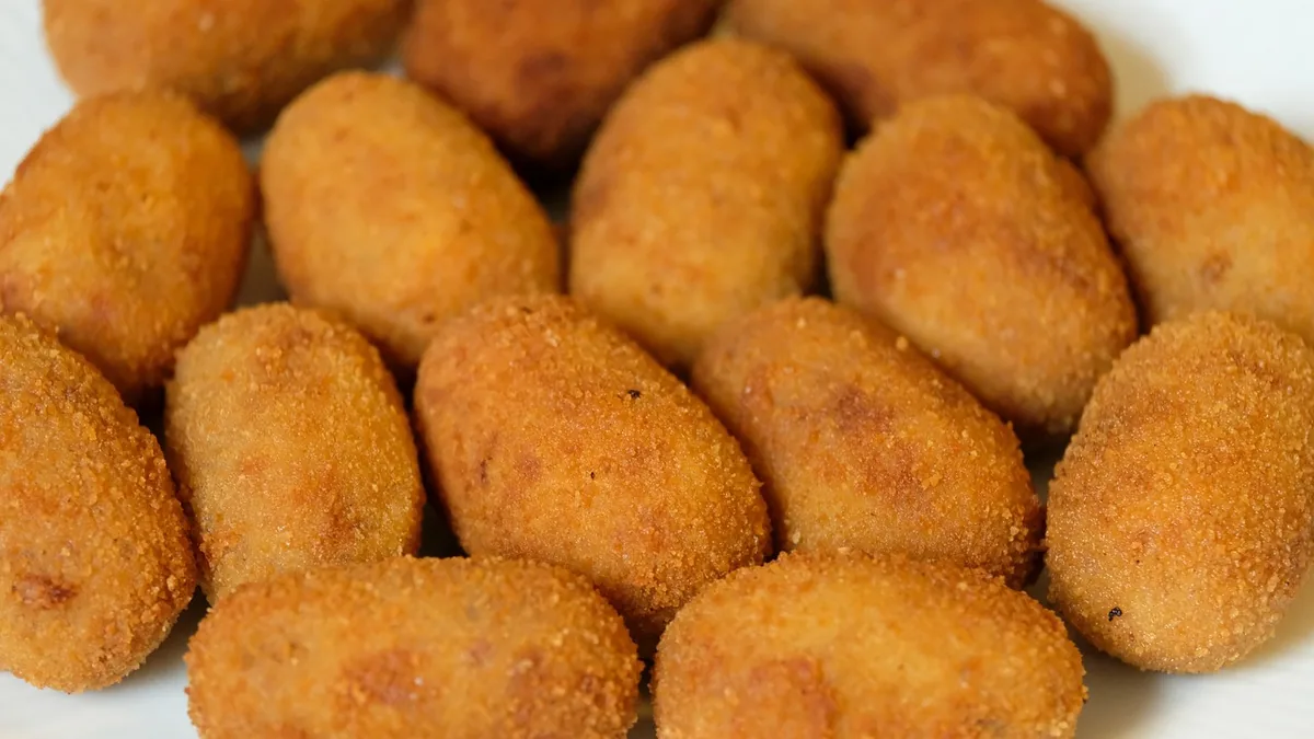 Golden fried croquettes piled on a plate, the crispy finish to aim for with this salmon croquettes recipe