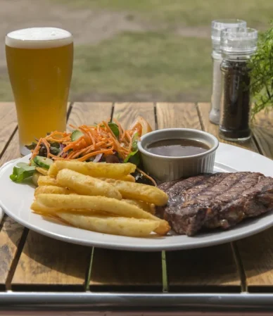 Seared steak with fries and a cup of sauce, served bistro style as in this steak au poivre recipe