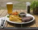 Seared steak with fries and a cup of sauce, served bistro style as in this steak au poivre recipe