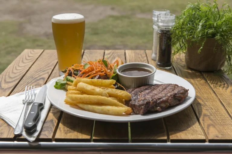 Seared steak with fries and a cup of sauce, served bistro style as in this steak au poivre recipe