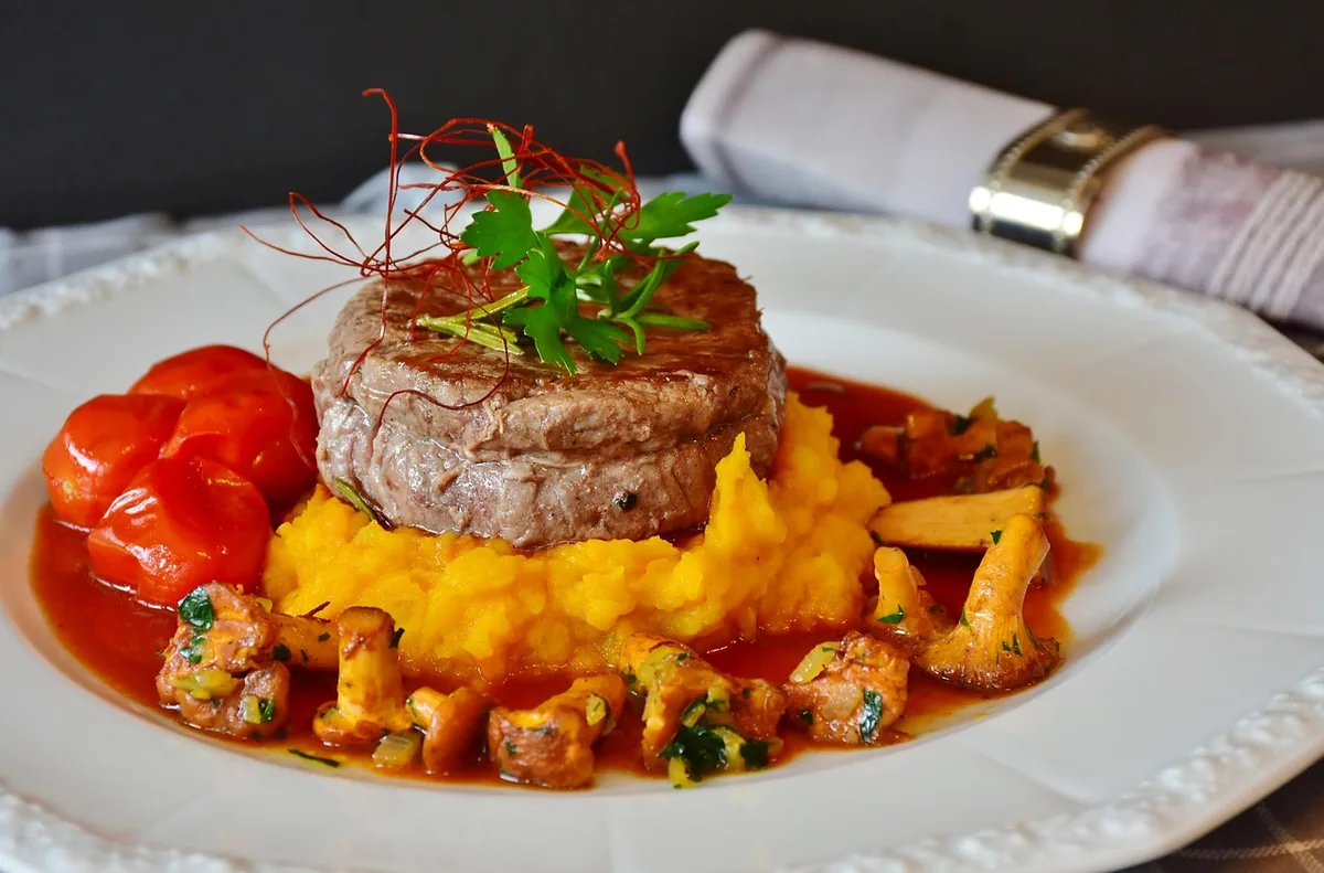 Seared beef steak with a glossy pan sauce over mashed potatoes
