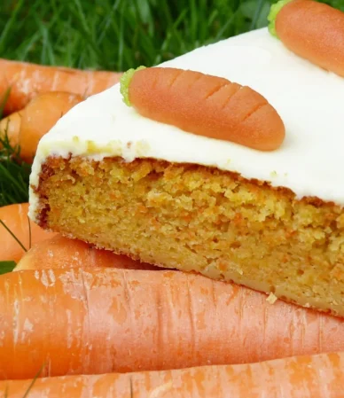Slice of carrot cake with cream cheese frosting and a little decorative carrot, the classic finish for this carrot cake recipe