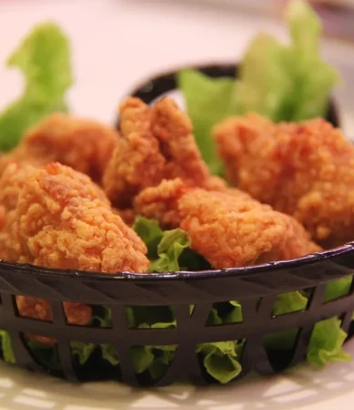 Basket of crispy fried chicken on lettuce, the result when you reheat fried chicken in the air fryer