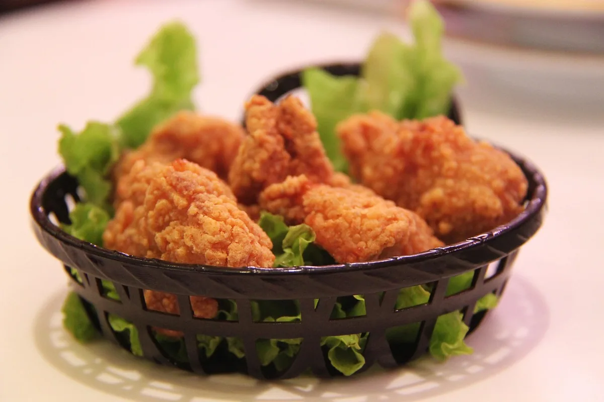 Basket of crispy fried chicken on lettuce, the result when you reheat fried chicken in the air fryer