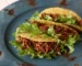 Ground beef tacos with lettuce on a blue plate, one of these healthy ground beef recipes