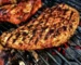 Seasoned smoked chicken breast with grill marks over hot coals