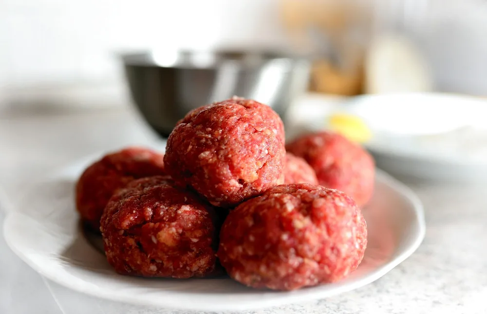 Raw ground beef meatballs shaped and ready to bake in the oven