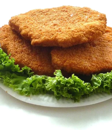 Air fryer chicken cutlets: three golden breaded chicken cutlets on a bed of curly lettuce