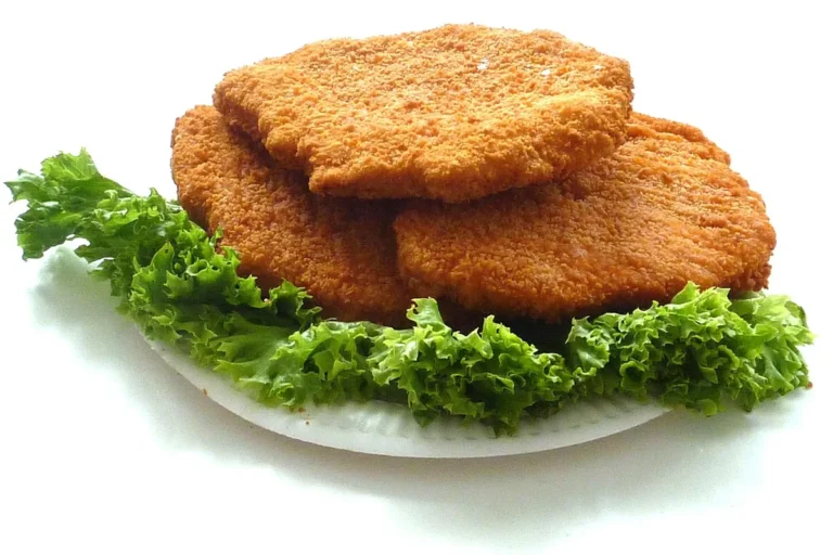 Air fryer chicken cutlets: three golden breaded chicken cutlets on a bed of curly lettuce