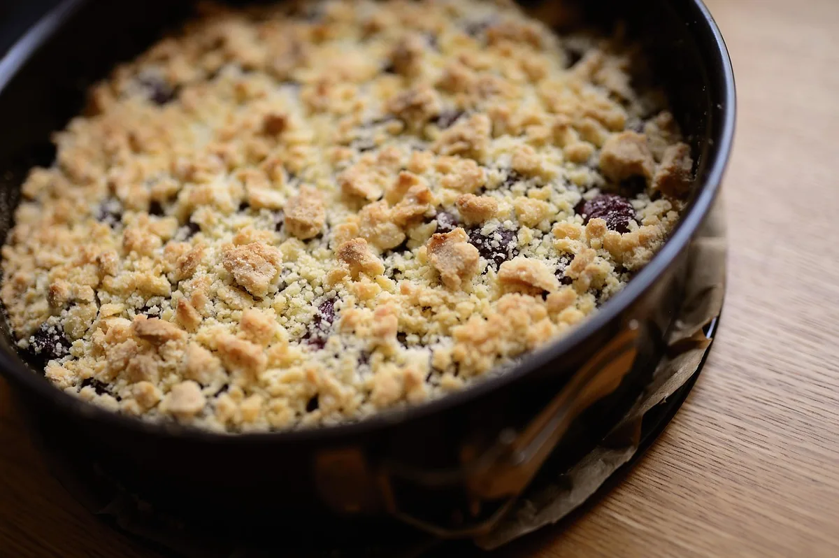 Cherry dump cake recipe idea: baked cherry dessert with a golden crumbly topping in a dark pan