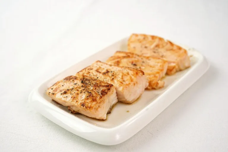 Air fry salmon recipe result: browned, flaky salmon fillet pieces on a white plate