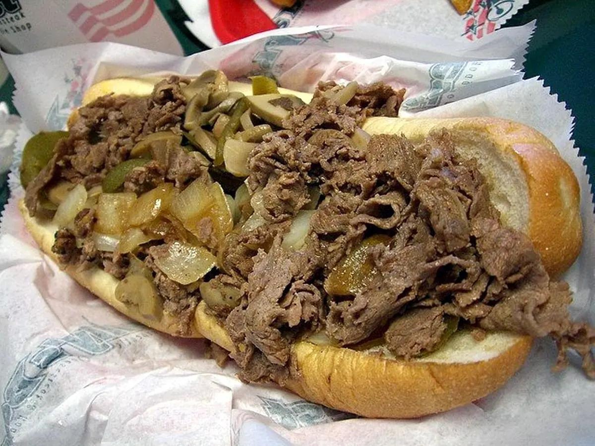Steak sandwich recipe idea: thinly sliced beef with sautéed onions and peppers in a hoagie roll