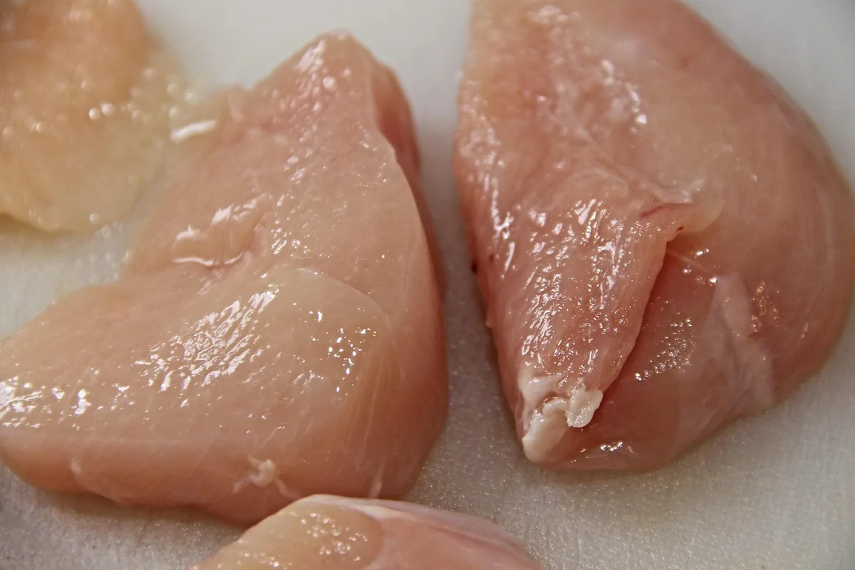 Raw boneless skinless chicken breasts ready to be pounded and seasoned