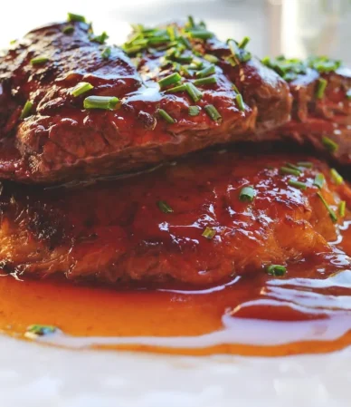 Browned steak in a glossy brown gravy with chives, similar to this cube steak recipe