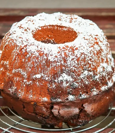 Bundt cake dusted with powdered sugar on a cooling rack, similar to this sweet potato pound cake recipe