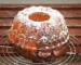 Bundt cake dusted with powdered sugar on a cooling rack, similar to this sweet potato pound cake recipe