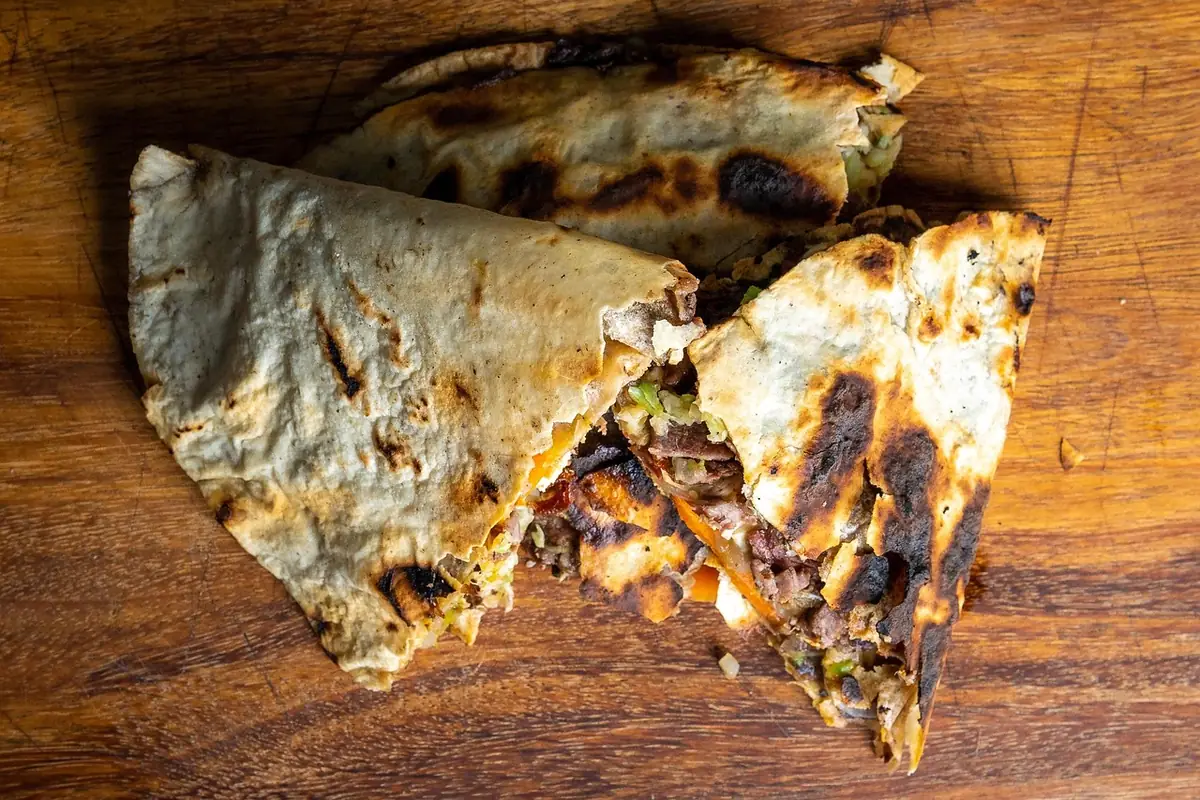 Grilled flour tortilla quesadilla cut open to show a chopped beef filling, similar to steak quesadillas