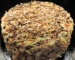 Tall round layer cake covered in toasted nuts with a chocolate drizzle, similar to this german chocolate cake recipe
