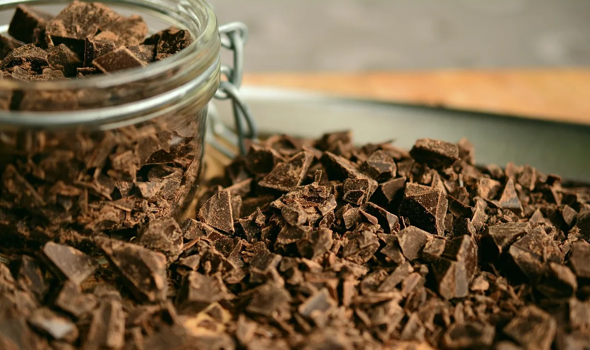 Finely chopped chocolate in a glass jar, ready to melt in hot water for the cake batter