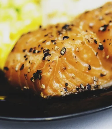 Peppered salmon fillet on a dark plate, similar to the result of how long to bake salmon at 350°F