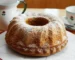 Golden Bundt cake dusted with powdered sugar on a plate, similar to this buttermilk pound cake recipe