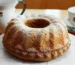 Golden Bundt cake dusted with powdered sugar on a plate, similar to this buttermilk pound cake recipe