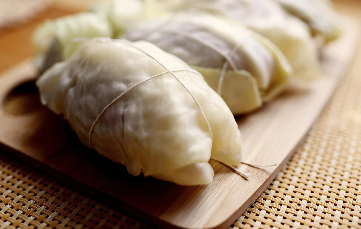 Classic stuffed cabbage rolls tied with string, the dish behind the unstuffed cabbage roll skillet