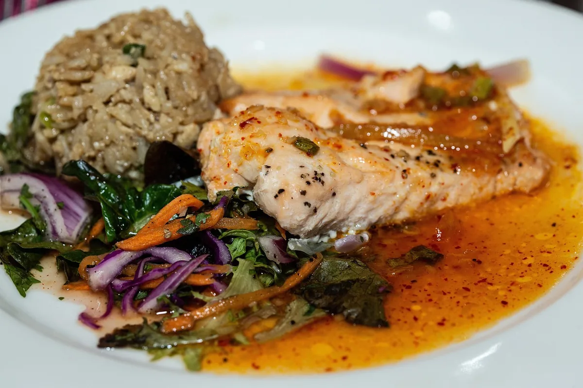 Glazed cooked salmon fillet with rice and shredded vegetables, similar to a cooked salmon bowl
