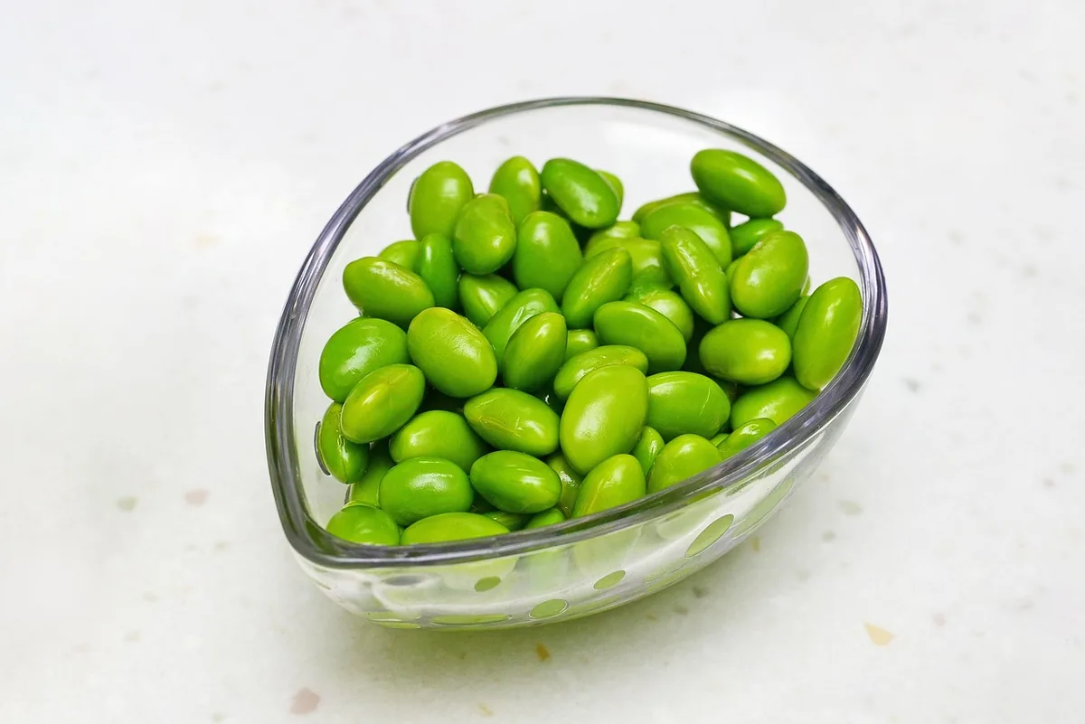 Shelled green edamame in a glass bowl, ready to top salmon rice bowls