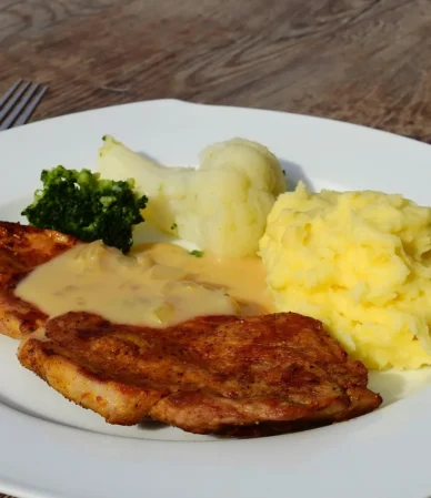 Golden breaded steaks with creamy gravy and mashed potatoes, similar to this country fried steak recipe
