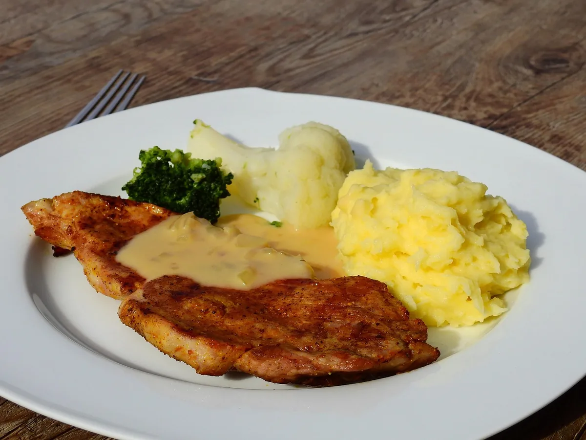 Golden breaded steaks with creamy gravy and mashed potatoes, similar to this country fried steak recipe