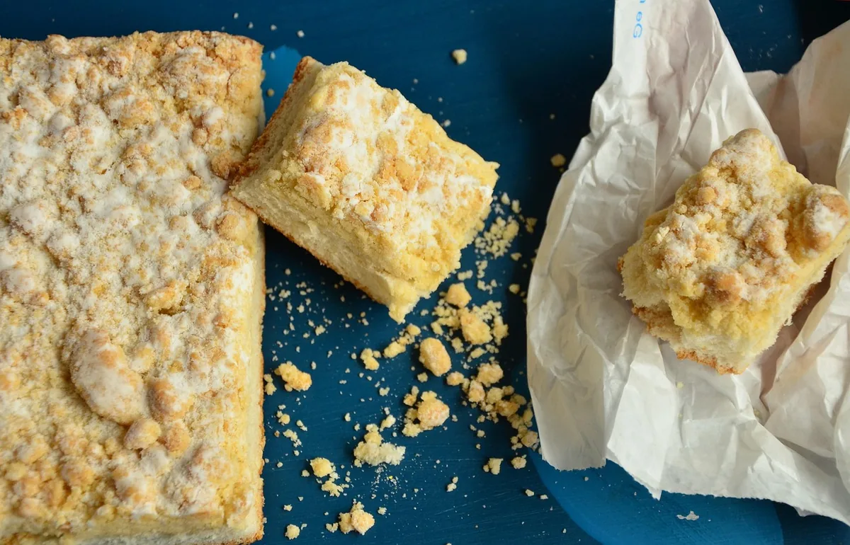 Golden, crumbly baked squares on parchment, similar to the buttery topping of a lemon dump cake