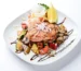Glazed salmon fillet over roasted vegetables with a dark sauce drizzle, similar to this teriyaki salmon recipe