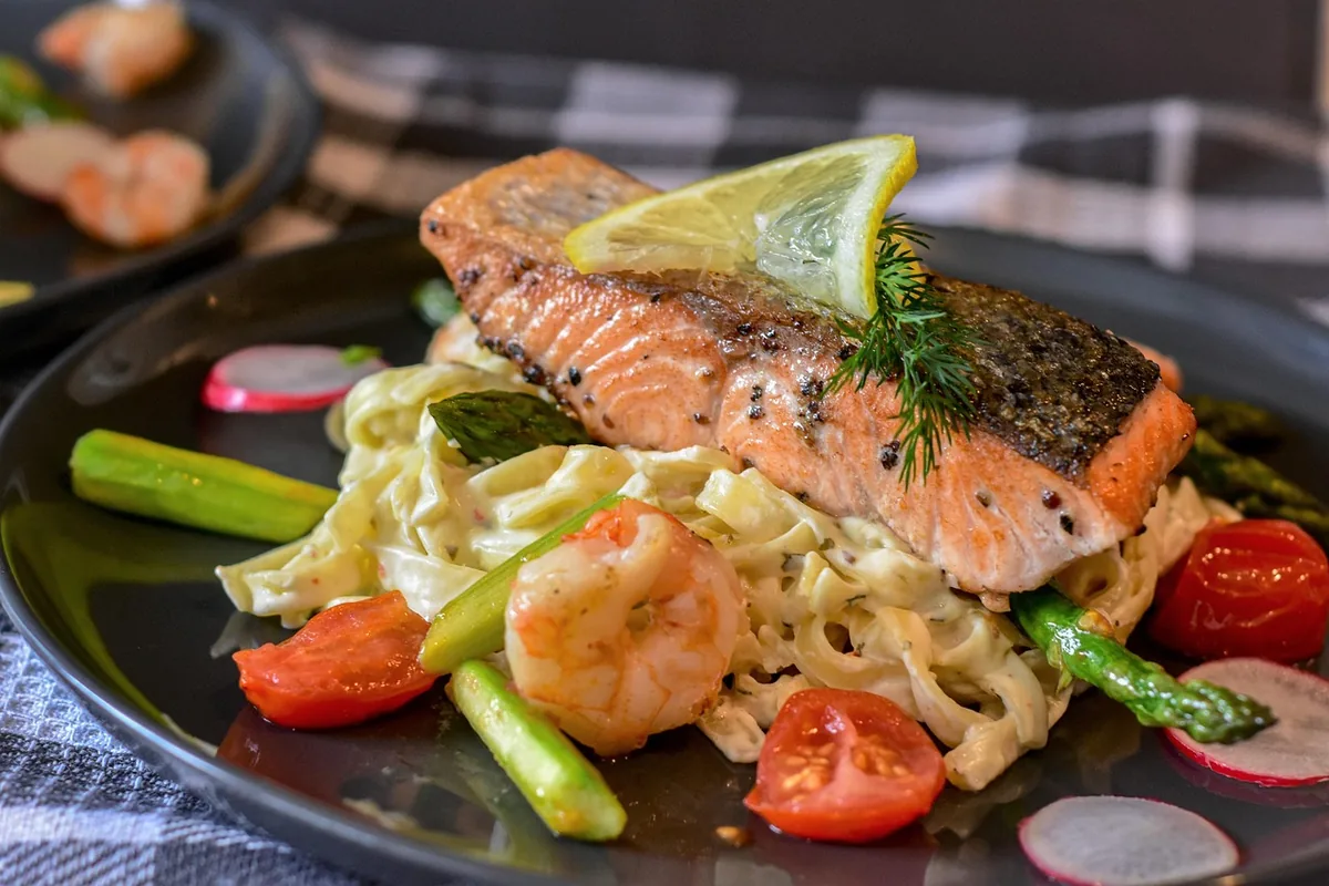 Seared salmon fillet served on a dark plate with vegetables, similar to baked teriyaki salmon