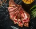 Sliced bone-in rib steak cooked medium-rare with peppercorns and rosemary, similar to this ribeye steak recipe