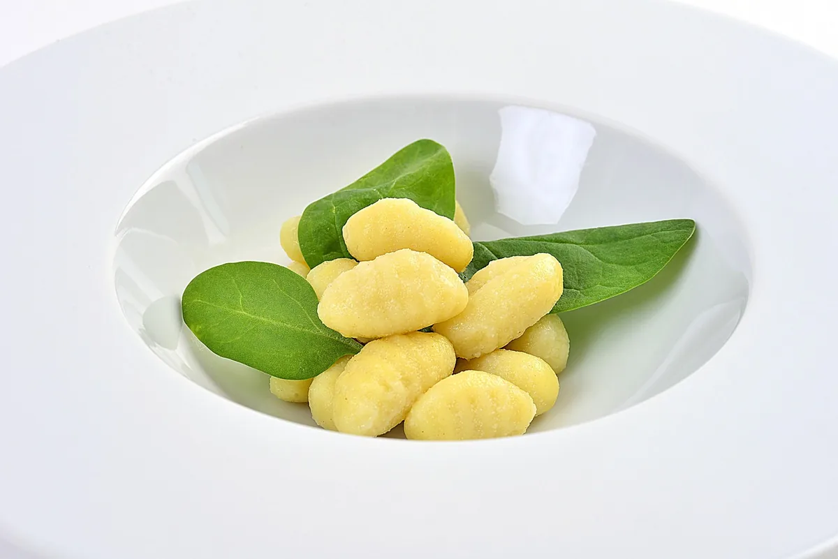 Potato gnocchi with fresh spinach leaves, ready to add to the soup