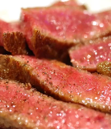 Seared beef sliced to show pink medium-rare centers, similar to this pan-seared eye of round steak