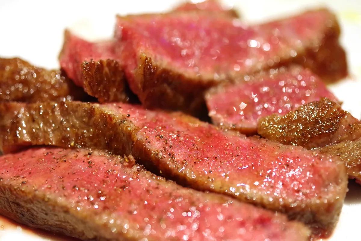 Seared beef sliced to show pink medium-rare centers, similar to this pan-seared eye of round steak